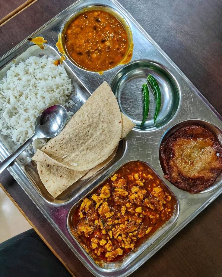 Freshly served hostel meal tray with rice, chapati, dal, vegetable curry and dessert