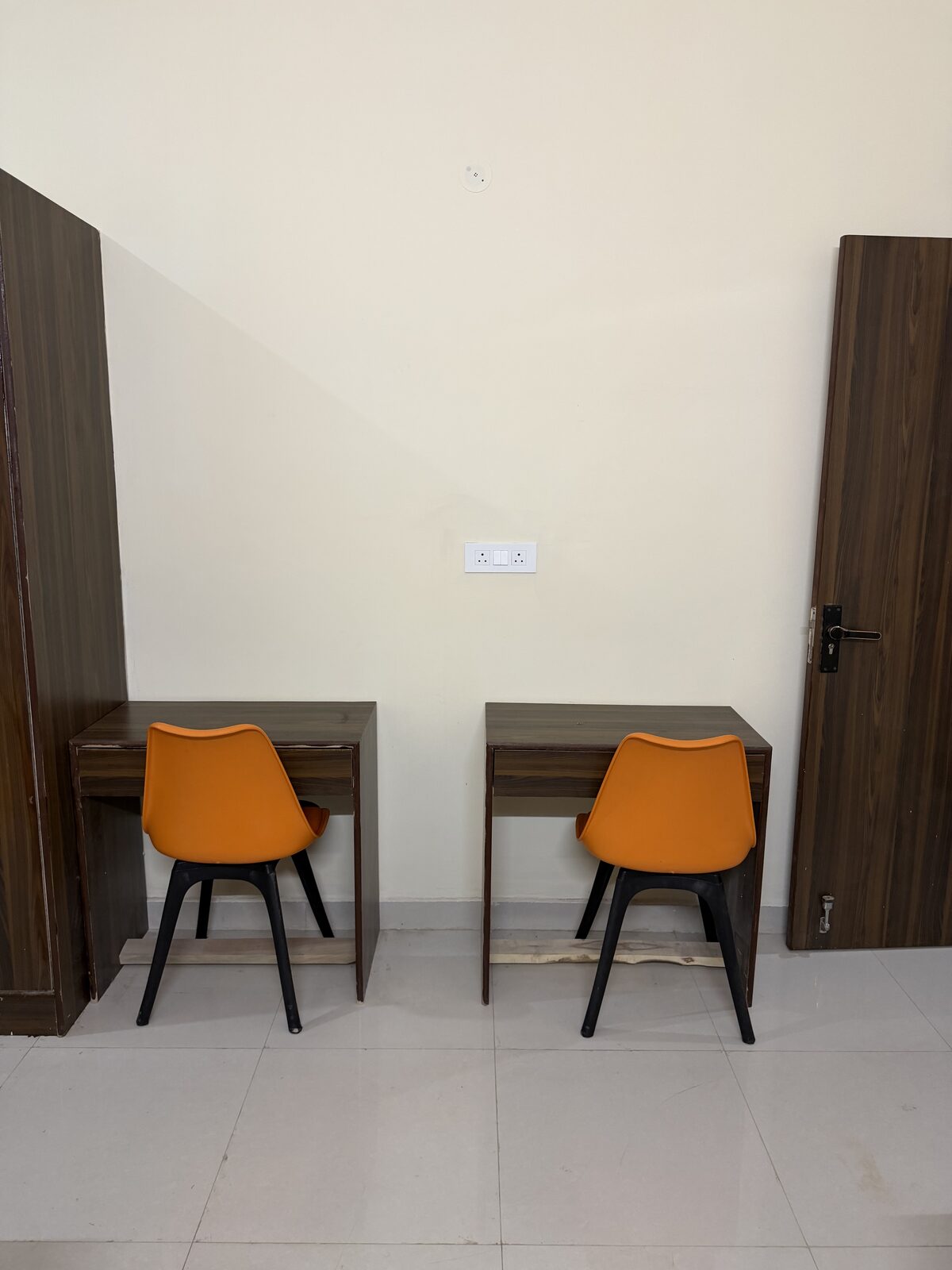 Triple sharing hostel room with study desks and chairs